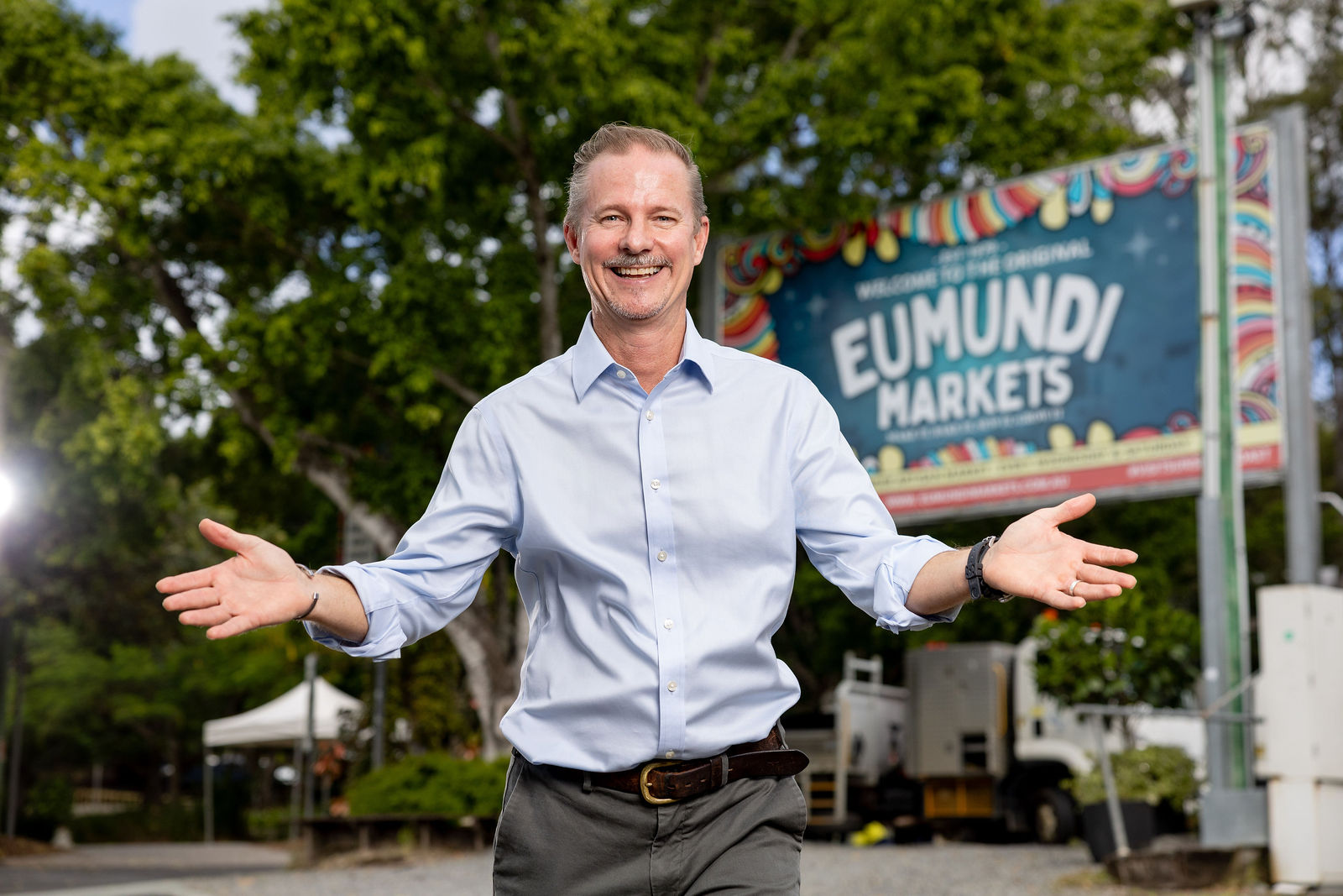 Mark Cameron outside the Eumundi Markets sign, home of the Experience Eumundi Sponsorship Program