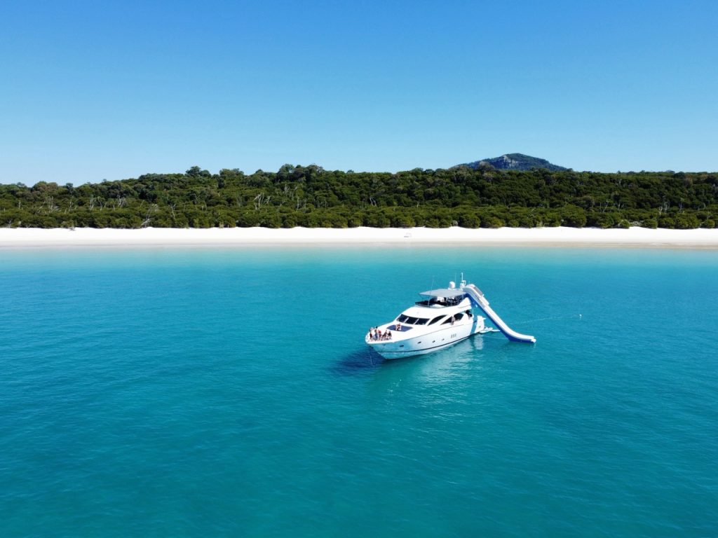 M/Y ALANI luxury yacht anchored in turquoise waters near Whitehaven Beach as part of the Nine Til Five experience.